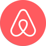 Das Bild zeigt das Airbnb-Logo, das eine stilisierte „A“-Form mit einer durchgehenden weißen Linie auf einem roten, kreisförmigen Hintergrund aufweist. Das Design ist schlicht und modern, spiegelt die Markenidentität des Unternehmens wider und ist eine ideale Empfehlung für die Präsentation minimalistischer Eleganz.